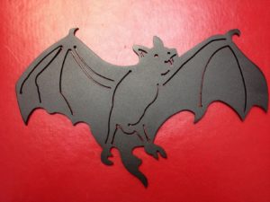 black bat flying powder coated black with red background