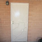 white custom security door with quail design from the larger company tucson image